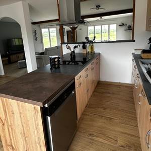 Cuisine moderne et tout équipée, ouverte sur le salon-salle à manger pour un séjour chaleureux et fonctionnel.