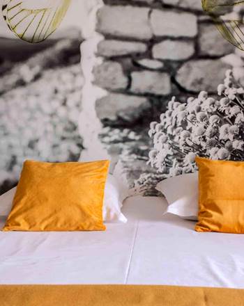Exemple de chambre double Éco & Cosy à Casa Nova, chambres d’hôtes à Sagone en Corse-du-Sud. Literie confortable, décoration personnalisée et ambiance chaleureuse aux touches jaunes.