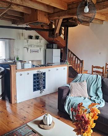 Pièce de vie aménagée au cœur du moulin avec les engrenages et les meules