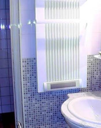 Salle d'eau avec cabine de douches, vasque, sèche serviettes, sèche cheveux, articles de toilette.