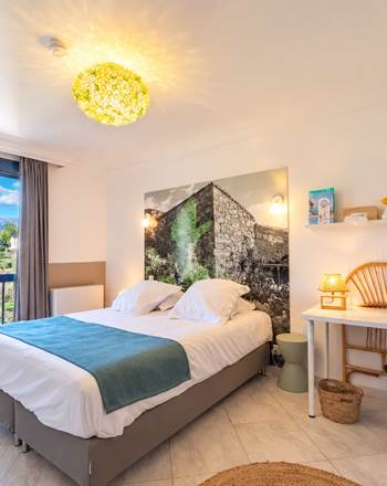 Première chambre de la Suite XL à Casa Nova, chambres d’hôtes à Sagone en Corse-du-Sud, avec lit double, espace bureau et vue sur les montagnes.