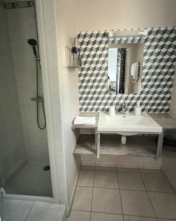 Salle d'eau équipée avec douche et lavabo dans la chambre d'hôtes familiale