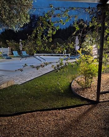 Ambiance estivale en soirée autour de la piscine chauffée de notre maison d'hôtes