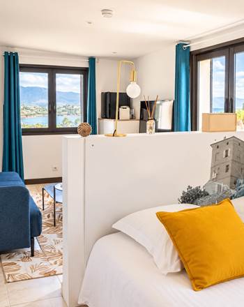Vue d'ensemble de la chambre Loft & Smart à Casa Nova : espace nuit et coin salon dans une grande chambre située à l'étage, avec vue mer.
