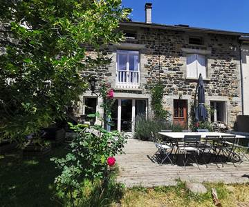 Terrasse privée équipée d'une table en pierre, salon de jardin, barbecue, parasol, éclairage à la guirlande guinguette pour vos soirées !