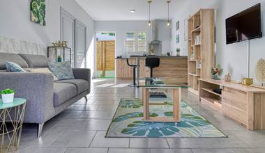 Appartement Chouchou à Hell-Bourg, avec un salon confortable, un coin repas convivial et une cuisine moderne ouverte, idéal pour un séjour à Salazie, La Réunion.