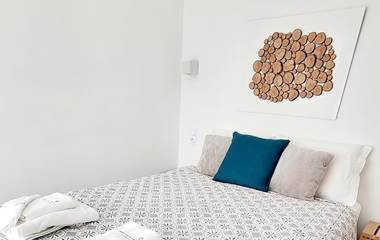 Petite chambre d'hôtes confortable et cosy avec décoration murale en bois naturel.