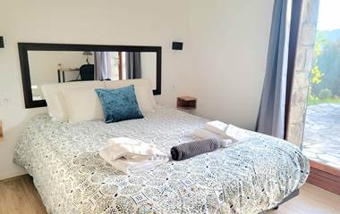 Chambre d'hôtes n°4 lumineuse avec lit queen size et accès direct à une terrasse privée.