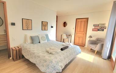 Chambre d'amis 1 spacieuse avec lit double, décoration naturelle et ambiance lumineuse au Domaine Cardu.