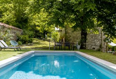 Table extérieure avec vue sur la piscine et le jardin arboré