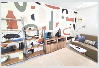 Maison Réthaise 2 – Séjour cosy et graphique Ambiance contemporaine dans un espace bien agencé, parfait pour savourer des moments de détente en centre-ville.