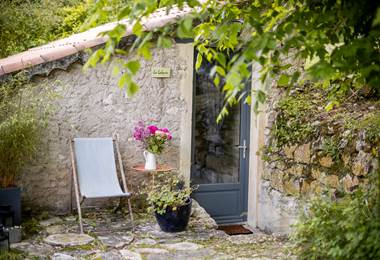 Façade en pierre de la Cabane avec coin détente extérieur