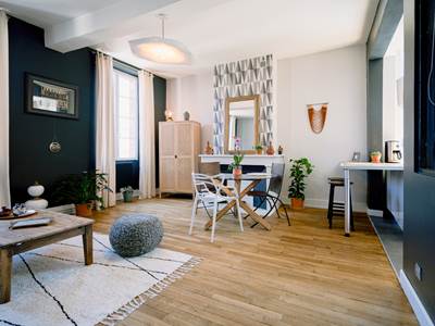 vue complete de la porte d'entre´e du se´jour avec la table a` manger en verre, la chemine´e, la table basse du salon. La cerrie`re a` droite. Alliance parfaite de la modernite´ et de la chaleur-presta