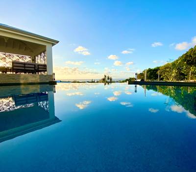 Piscine à débordement vue mer avec coin salon sous le carbet