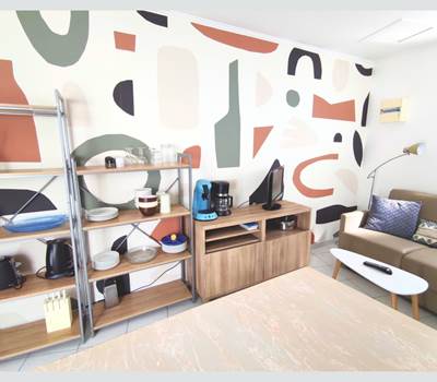 Maison Réthaise 2 – Séjour cosy et graphique Ambiance contemporaine dans un espace bien agencé, parfait pour savourer des moments de détente en centre-ville.