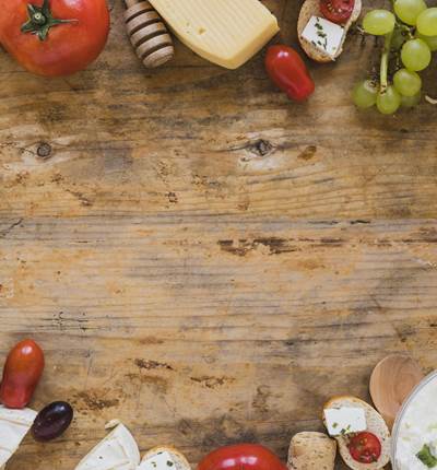 plateau-de-fromages-avec-tomates-raisins-et-mini-sandwichs-sur-un-bureau-en-bois-avec-espace-pour-ecrire-le-texte-min