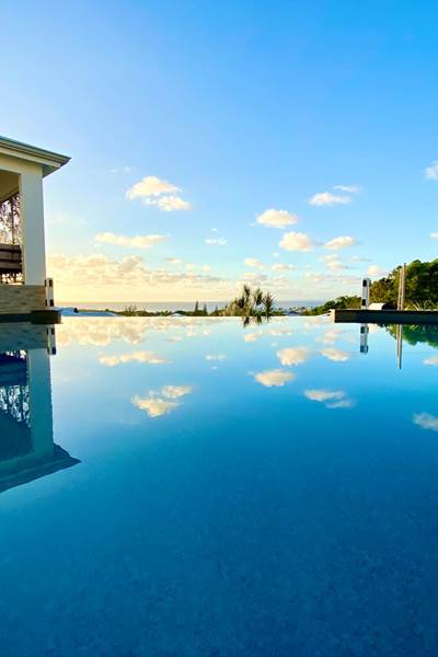 Piscine à débordement vue mer avec coin salon sous le carbet