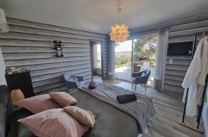 grande chambre avec coin salon séparée de la cuisine et de la salle d'eau