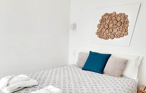 Petite chambre d'hôtes confortable et cosy avec décoration murale en bois naturel.