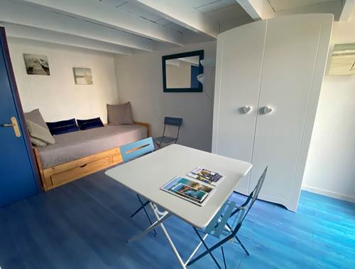 Espace salon séjour avec 1 lit gigogne formant un lit de 180cm et servant de canapé