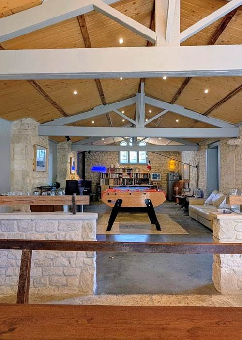 Salle de jeux avec baby-foot, ping-pong, bibliothèque et poêle à granulés