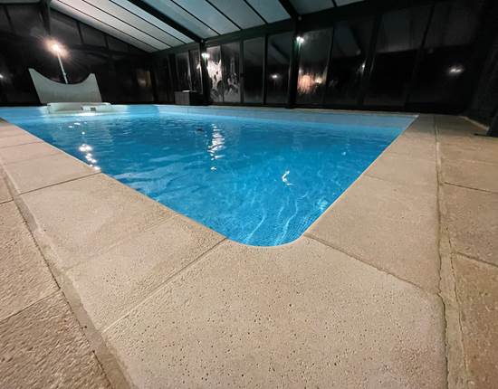 Grande piscine couverte éclairée le soir