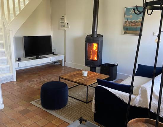 Le salon avec TV et poêle à bois