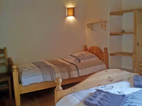 Vue de la chambre et ses deux lits. Parquet en bois massif