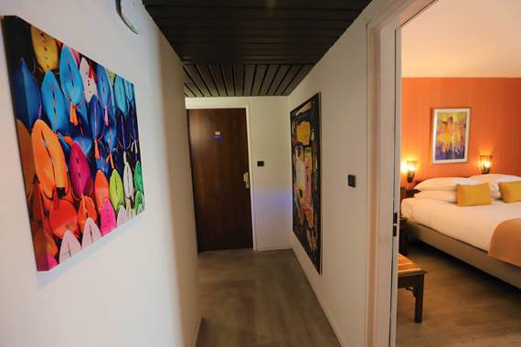 Couloir avec tableaux et chambre triple petit balcon