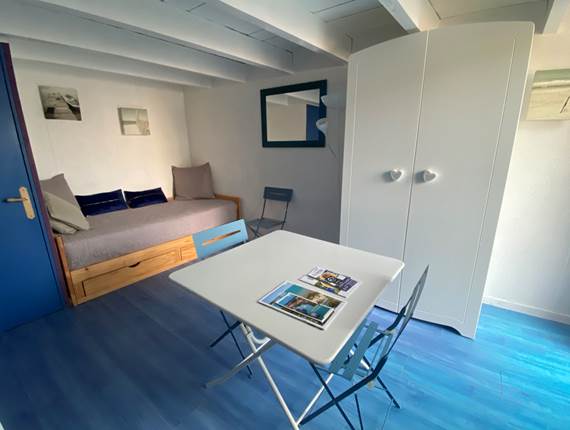 Espace salon séjour avec 1 lit gigogne formant un lit de 180cm et servant de canapé