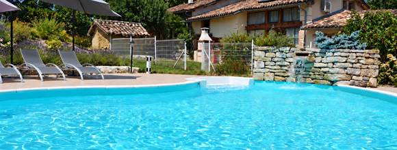 Piscine, cascade et transats gris