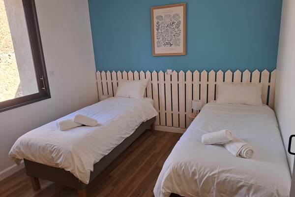 Chambre avec deux lits simples du gîte Le Pressoir à Montblanc, idéale pour enfants ou amis.