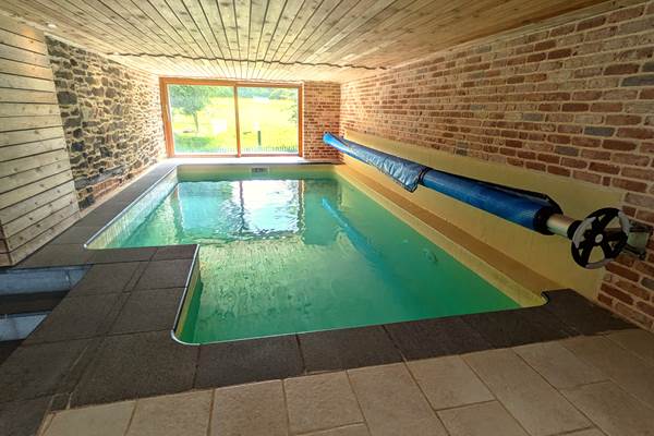 Indoor swimming pool with panoramic view over horse fields and countryside