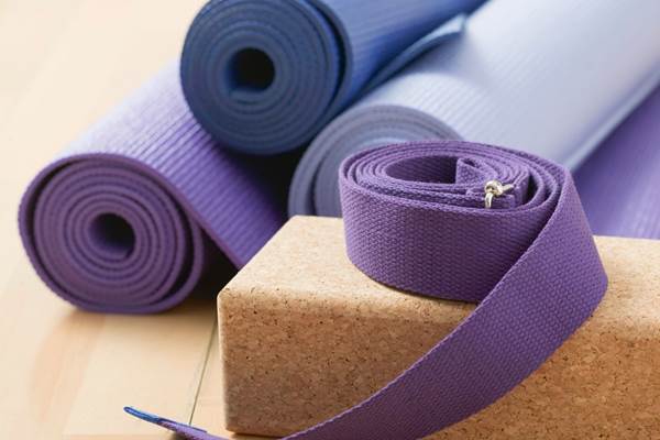 Salle équipée de tapis caoutchouc, briques, sangles, bolster...