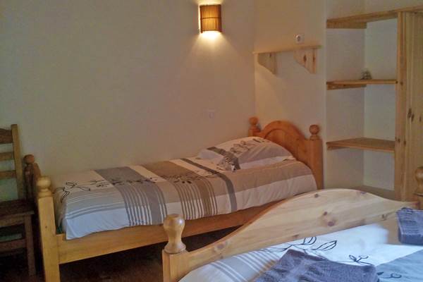 Vue de la chambre et ses deux lits. Parquet en bois massif