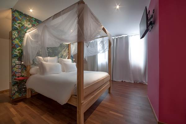 <img src="chemin-de-l-image.jpg" alt="Grande suite Grenade avec lit confortable et vue sur le jardin tropical à l'hôtel de charme La Maison de Clémentine, Fort-de-France, Martinique"