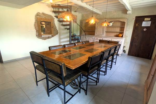 Bright family dining room with large table and children’s seating in holiday gîte