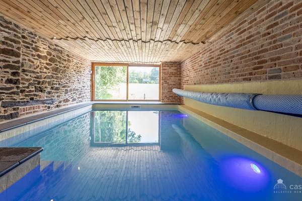 alt="Piscine intérieure chauffée du grand gîte familial en Ardenne belge pour séjours en groupe et vacances en famille"