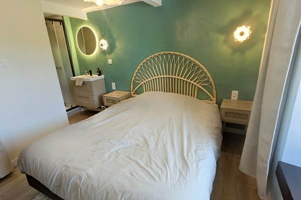 alt="Chambre élégante avec lit queen size et salle de douche privative dans le gîte familial en Ardenne belge"