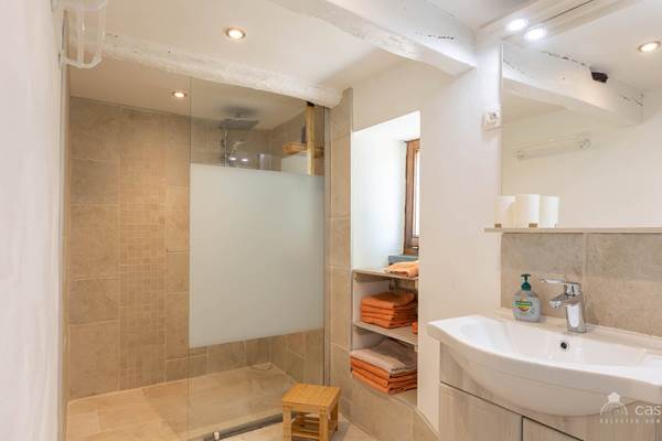 alt="Salle de bain moderne partagée entre les chambres king size du grand gîte familial en Ardenne belge"