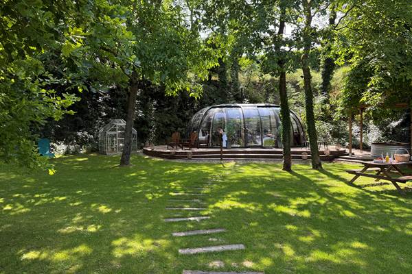 Bulle installée sur un terrain arboré et ombragé.