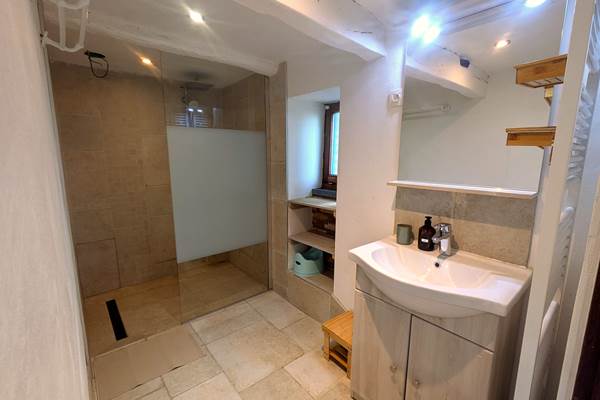"Walk-in shower room with natural stone tiles – Villa Hérisson gîte