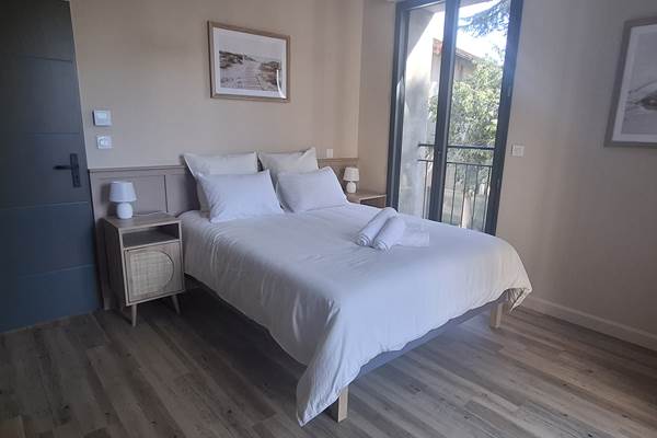 Suite parentale du gîte Le Pressoir à Montblanc, lit double et espace lumineux.