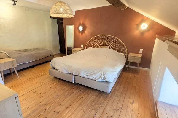 alt="Chambre familiale avec lit king size, lit simple et salle de douche privative dans le gîte grande capacité"