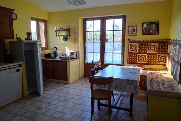 Cuisine fonctionnelle, lumineuse et entièrement équipée, avec espace repas, vue nature et accès direct jardin