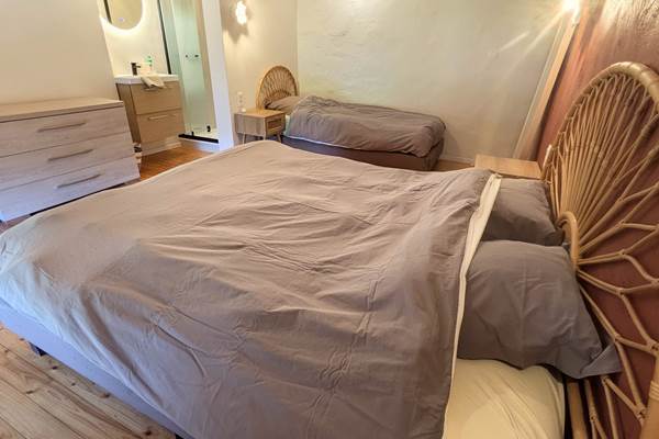 alt="Grande chambre avec couchages familiaux et douche privée dans le gîte pour groupes en Ardenne belge"