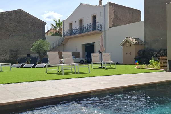 Piscine du gîte Le Ramonetage aux Gîtes de Monte Blanco à Montblanc, avec transats et parasols en été
