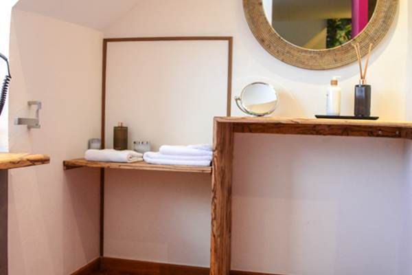 <img src="chemin-de-l-image.jpg" alt="Salle de bain lumineuse avec miroir et sèche-cheveux dans la suite Mayero, hôtel La Maison de Clémentine, Fort-de-France, Martinique" />