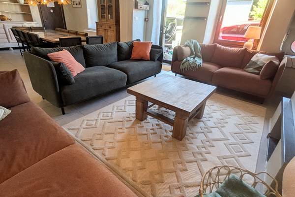 alt="Salon chaleureux avec canapés confortables dans le grand gîte familial en Ardenne belge"