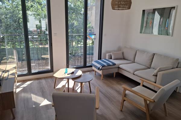 Salon confortable du gîte Le Pressoir avec vue sur la terrasse, au cœur de Montblanc.